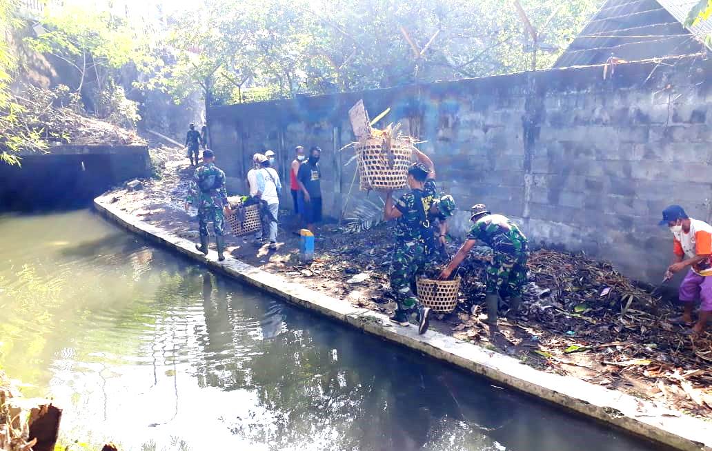 Anggota Satgas Bersihkan lingkungan di Lokasi Sasaran TMMD